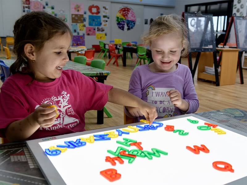 Two children playing with letters